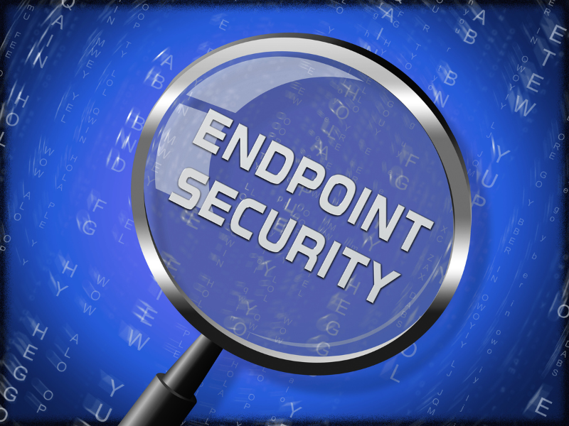 A magnifying glass zooms in on the words “ENDPOINT SECURITY” against a digital blue background, symbolizing the scrutiny and protection of devices connected to a network as part of cyber security solutions.